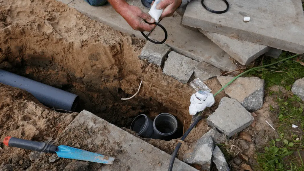 The ground is dug up revealing sewer pipes.