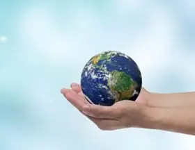 A pair of hands gently cradles a small Earth, symbolizing the importance of protecting and preserving our planet.