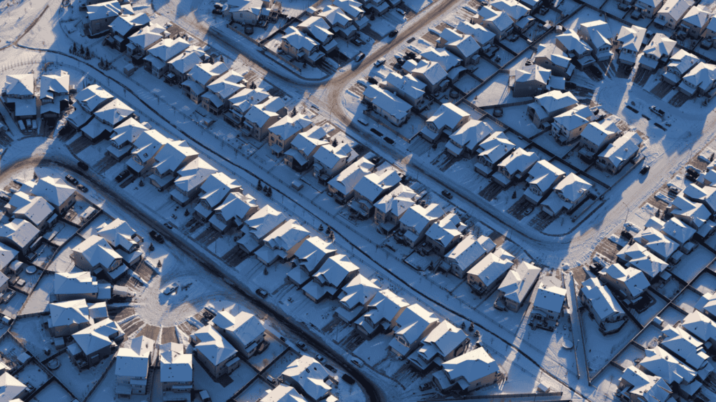 An aerial view of a suburban neighborhood covered in snow.