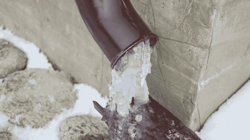 An outdoor pipe that has broken from freezing water.